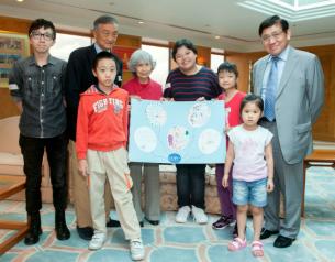 癌病儿童送上亲手绘画的作品，以答谢新地主席兼董事总经理郭炳联（右一）的支持和鼓励