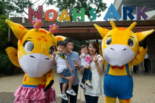Mascots Smart Giraffe (right) and Pretty Giraffe pose with visitors